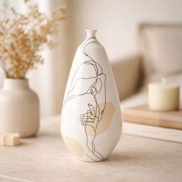 White ceramic artistic face vase displayed on wooden table creating elegant and creative interior decor accent.