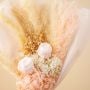 Closeup of pastel dried bouquet with preserved pampas grass light pink hydrangea infinity rose and delicate babysbreath creating a rustic floral gift.