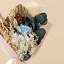 Closeup of Infinity Rose bouquet with preserved flowers pine cone and hydrangea arrangement.