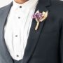 Elegant groom wedding boutonniere with purple artificial flower and jute wrap displayed on black background for decor.