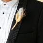Boutonniere with beige and white dried grass stems wrapped in jute displayed on black background.