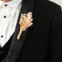 Elegant boutonniere on black background featuring dried flowers rustic groom lapel pin wedding decor.