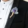 Elegant dried flower boutonniere in purple and blue shades displayed on black background for groom wedding accessory styling.