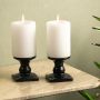 Modern black glass candle holder with candle lit shown on white background for home and dining decor.