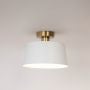 White dome semi flush ceiling light with gold base illuminated on white background ideal for modern and minimalist home decor.