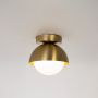 Gold ceiling light with frosted glass globe shade glowing warm on white background for home lighting