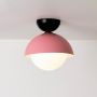 Ceiling light shown on a clean white background with a pink dome shade and a white globe for a modern fresh look.