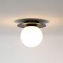 Black ceiling light with frosted glass globe shade glowing warmly on plain white background for home lighting.