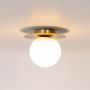 Brushed gold ceiling light with frosted glass globe shade glowing warmly on plain white background for home lighting.