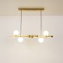 Gold metal linear pendant light with frosted glass globe shades illuminated showcasing balanced design for dining and kitchen ceilings.