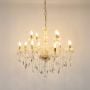 Elegant chandelier with crystal and gold accents illuminated on white background for luxury interior design.