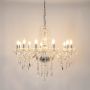 Crystal chandelier with silver detailing glowing brightly on white background for elegant luxury interior lighting.