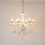 White chandelier with crystal and silver finish illuminated on white background for luxury decorative lighting.