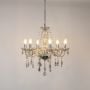 Golden crystal chandelier with silver finish glowing brightly on white background for modern luxury interior.