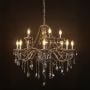 Elegant chandelier with smoky crystal and silver finish illuminated against black background for modern decor.