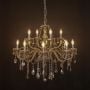 Elegant chandelier with golden crystal finish illuminated against black background for stylish home lighting.