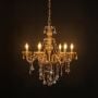 Illuminated crystal-chandelier with glowing bulbs and sparkling crystals on black background.