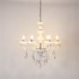 Chandelier with lights on glowing warmly with crystal details and glass accents photographed on white background.