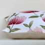 Soft cotton cushion cover with bold red floral embroidery shown at an angle adding a bright nature inspired décor element with a breathable gentle and skin friendly fabric suitable for all interiors.