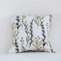 Cotton cushion with intricate botanical embroidery set against a white background highlighting warm yellow and grey stitched details for elegant decor styling.