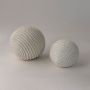 Decorative textured ceramic spheres in white finish styled together for modern home and tabletop accents.