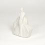 White ceramic minimalist sitting human statue with textured rock base for shelf styling and home decor display.