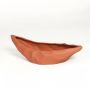 Orange ceramic decorative platter with textured faceted surface isolated on clean white background for stylish interior decor.