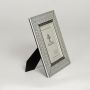 Silver metal photo frame with detailed border design isolated on clean white background for elegant tabletop decor use.