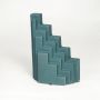 Teal ceramic stepped decorative sculpture with layered geometric design isolated on white background for contemporary decor display.