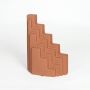 Orange ceramic stepped decorative sculpture with angular layered form isolated on clean white background for stylish interior decor use.
