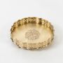 Decorative round brass plate in gold finish with scalloped edges and engraved floral design on white background.