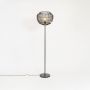 Contemporary black rattan floor lamp with glowing bulb design for stylish home lighting.