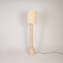 Floor lamp turned off on white background displaying full height form stacked base and clean drum shade for clear product visibility.