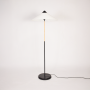 Floor lamp turned off on white background highlighting sculpted column base fabric shade proportions and clean modern design aesthetic.