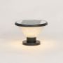 Solar pillar light glowing brightly with black metal base and clear textured glass ideal for exterior lighting.