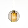 Golden glass hanging pendant light illuminated on plain white backdrop highlighting modern design.