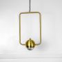 Elegant brass gold wall lamp with frosted glass globe and metal frame shown turned off highlighting minimalist design.