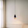 Minimal pendant light with metal body hanging near wall adding subtle warm lighting and clean modern touch to interior space.