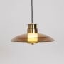 Pendant light with golden finish and glass shade ceiling lamp photographed glowing on white background.