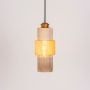 Pendant light with ribbed glass body and brass finish glowing warmly on white background for stylish ceiling lighting.