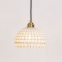 White woven pendant light with gold mount illuminated on a clean white background showing its airy design.