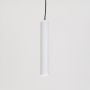 White tubular pendant light glowing softly on a white background creating focused downward illumination.