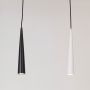 Black and white cone pendant lights in metal finish glowing warmly on white background for modern home interior décor.