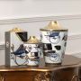 Pair of white ceramic jars with blue and gold artwork in a front view perfect for luxury décor styling and artistic console display.