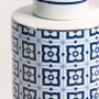 Close detail of ceramic jar showing glossy surface with blue floral tile-inspired patterns.