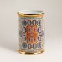 Ceramic holder with orange and blue geometric design and golden rim on white background for elegant interiors.