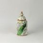 Stylish decorative jar with vibrant peacock artwork and gold-tipped lid enhancing charm of modern living spaces.