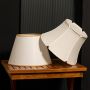Two elegant fabric lampshades displayed together on a wooden table with a soft light off black background creating a stylish grouped presentation for home decor.