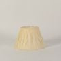 Cream pleated lampshade shown on bright white surface capturing its gentle tone and neatly crafted pleats for a stylish lighting accessory.