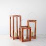 Set of three wooden lanterns in small medium and large sizes displayed together for decorative styling inspiration.